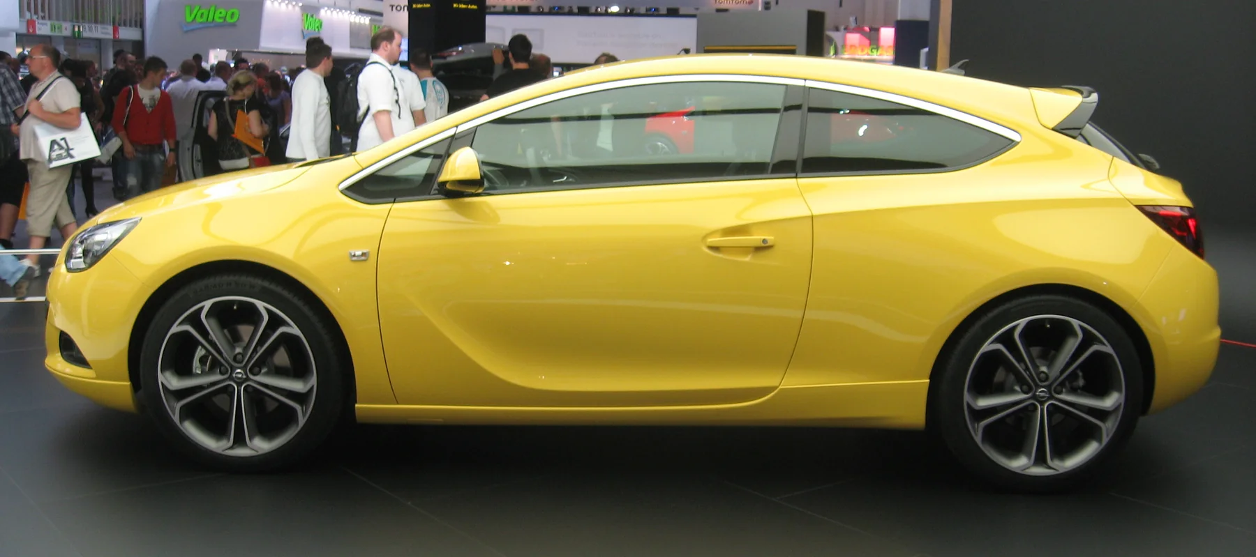 Жёлтый Opel Astra J GTC, вид строго сбоку